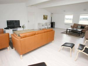 - un salon avec un grand canapé orange et des chaises dans l'établissement 16 person holiday home in Brovst, à Brovst