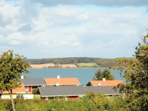 un grupo de casas con un lago en el fondo en 8 person holiday home in Aabenraa, en Løjt