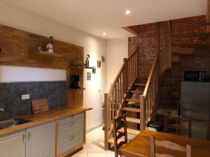 cocina con escalera de madera y encimeras de cocina en Le Domaine Des Zoiseaux - LDDZ des Flandres, en Vieux-Berquin