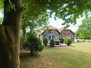 una casa grande con un árbol delante en Four-Bedroom Holiday home in Hemmet 15, en Hemmet