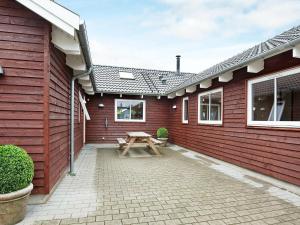 uma mesa de piquenique no pátio de uma casa vermelha em 18 person holiday home in Nordborg em Nordborg