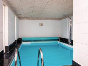 a large swimming pool with blue water in a room at 10 person holiday home in Alling bro in Nørager