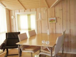 a wooden dining room with a table and chairs at 5 person holiday home in R dby in Kramnitse