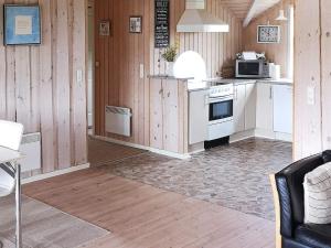a kitchen with white appliances and wooden walls at 5 person holiday home in R dby in Kramnitse