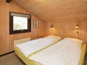 BindslevにあるThree-Bedroom Holiday home in Bindslev 3の木製の部屋に大型ベッドが備わるベッドルーム1室が備わります。