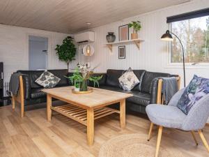 sala de estar con sofá negro y mesa en 14 person holiday home in rsted, en Kare