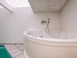 baño con bañera blanca y ventana en 14 person holiday home in rsted en Kare