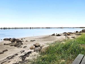 una spiaggia con rocce e acqua sullo sfondo di 8 person holiday home in Storvorde a Egense