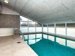 a swimming pool with a bath tub and a swimming pool at Five-Bedroom Holiday home in Ebeltoft 3 in Ebeltoft