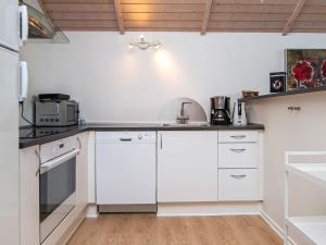 cocina con armarios blancos y fogones en 8 person holiday home in Haderslev en Kelstrup Strand