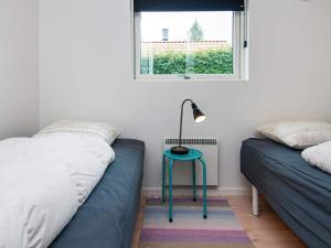 8 person holiday home in Haderslev في Kelstrup Strand: غرفة نوم بسريرين ومصباح على طاولة