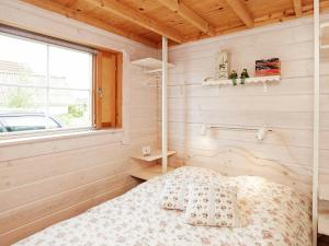Flovtrupにある6 person holiday home in Roslevの木製の部屋にベッド1台が備わるベッドルーム1室があります。