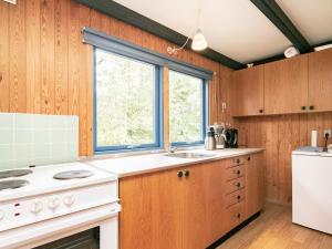 a kitchen with a white stove and a window at 5 person holiday home in H jslev in Bøstrup
