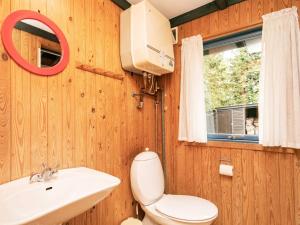 a bathroom with a toilet and a sink and a window at 5 person holiday home in H jslev in Bøstrup