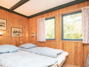 Bøstrupにある5 person holiday home in H jslevのウッドパネルの部屋 ベッド2台 窓2つ付