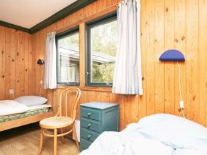 Bøstrupにある5 person holiday home in H jslevの木製の壁のベッドルーム1室、ベッド1台、窓が備わります。