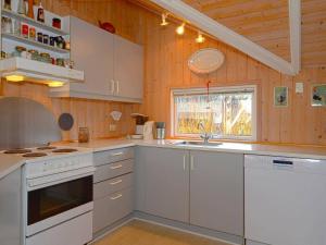 Hemmetにある8 person holiday home in Hemmetの白い家電製品と木製の壁が備わるキッチン
