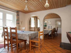 cocina y comedor con mesa y sillas en Cozy Holiday Home in Thyholm with Swimming Pool, en Thyholm