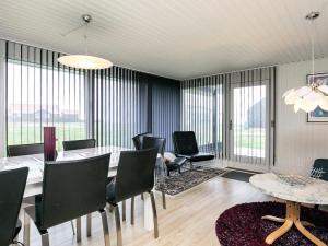 a dining room with a table and chairs and windows at 6 person holiday home in Vinderup in Vinderup