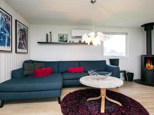a living room with a blue couch and a table at 6 person holiday home in Vinderup in Vinderup