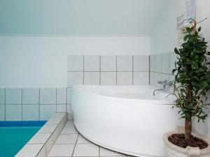 a bathroom with a bath tub and a potted plant at 10 person holiday home in Juelsminde in Sønderby
