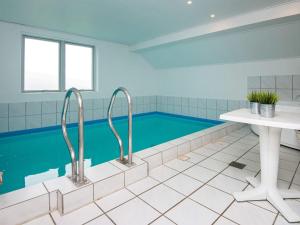 a swimming pool in a bathroom with a white table at 10 person holiday home in Juelsminde in Sønderby
