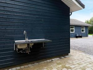 ein Waschbecken an der Seite einer schwarzen Wand in der Unterkunft 14 person holiday home in H jslev in Bøstrup
