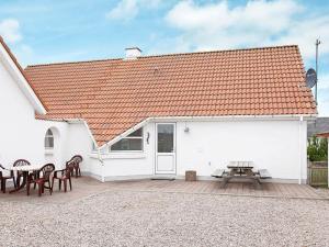 un edificio blanco con sillas y mesa de picnic en 10 person holiday home in Thisted, en Klitmøller