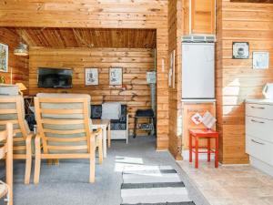Lem的住宿－4 person holiday home in Skjern，厨房设有木墙、椅子和冰箱