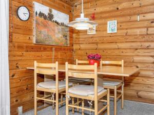 a dining room with a table and chairs and a clock at 4 person holiday home in Skjern in Lem