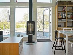 un soggiorno con camino, tavolo e sedie di Holiday Home Dalby a Henån