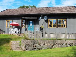 ein kleines graues Haus mit einem Tisch und einem Regenschirm in der Unterkunft 5 person holiday home in ASKER ARNA in Buvik