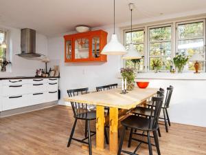 Skødshoved Strandにある6 person holiday home in Knebelのキッチン、ダイニングルーム(木製のテーブルと椅子付)