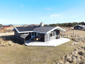 uma casa com telhado solar num campo em Three-Bedroom Holiday home in Hirtshals 4 em Hirtshals