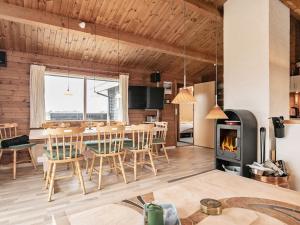 a kitchen and dining room with a table and a fireplace at Cozy Beach House in Kjul - By Traum Ferienwohnungen in Hirtshals