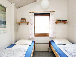 two beds in a room with a window at Cozy Beach House in Kjul - By Traum Ferienwohnungen in Hirtshals