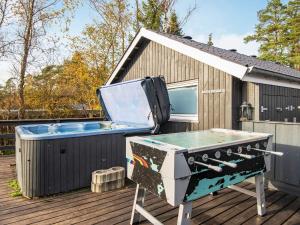 een grill en een hot tub op een terras bij 6 person holiday home in Ebeltoft in Øksenmølle