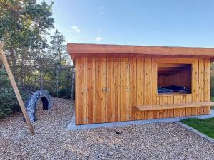 a wooden dog house with a bed in it at 10 person holiday home in Hadsund-By Traum in Nørre Hurup
