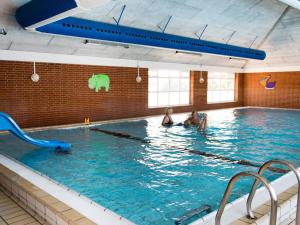 two people swimming in a large swimming pool at Seaside Retreat at Rim - By Traum Ferienwohnungen in Rømø Kirkeby +34 photos