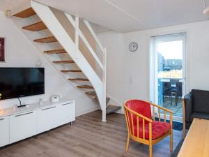a living room with a tv and a staircase at Seaside Retreat at Rim - By Traum Ferienwohnungen in Rømø Kirkeby