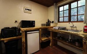 a kitchen with a counter with a sink and a refrigerator at Away with the Fairies in Hogsback