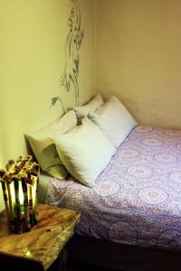 Una cama con almohadas blancas y una mesa en una habitación en Away with the Fairies, en Hogsback
