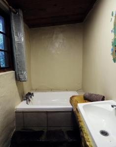 a bathroom with a white tub and a sink at Away with the Fairies in Hogsback