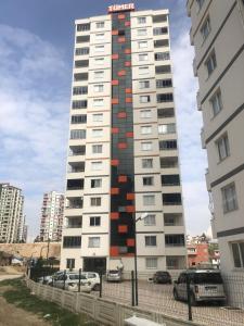 a tall white building with red squares on it at 2+1 RESIDENCE STADYUM in Sarıhamzalı