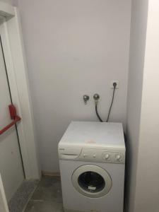 uma máquina de lavar roupa num canto de um quarto em 2+1 RESIDENCE STADYUM em Sarıhamzalı