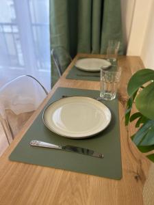 une table avec deux plaques et une fourchette et un couteau dans l'établissement Studio cosy à 15min de Paris, à Antony