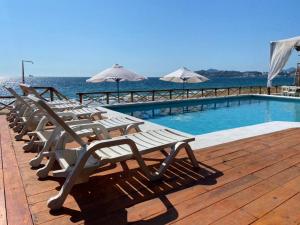 a row of lounge chairs next to a swimming pool at El Encanto Casa Boutique in Manzanillo