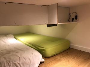 uma cama com um colchão verde num quarto em Logement neuf avec jardin privé 4 couchages Option piscine em Les Iffs
