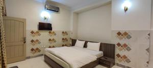a bedroom with a bed and a television and a door at SWAT GUEST HOUSE in Mingāora