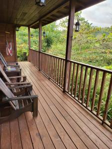una veranda in legno di una cabina con panchina di Private Mountaintop Cabin in Carara Biological Corridor 20 minutes to beaches a Carara